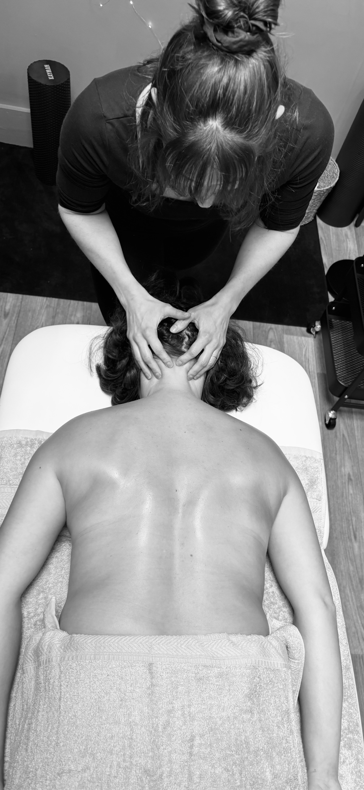 Clare working on a client's neck from the head of the table